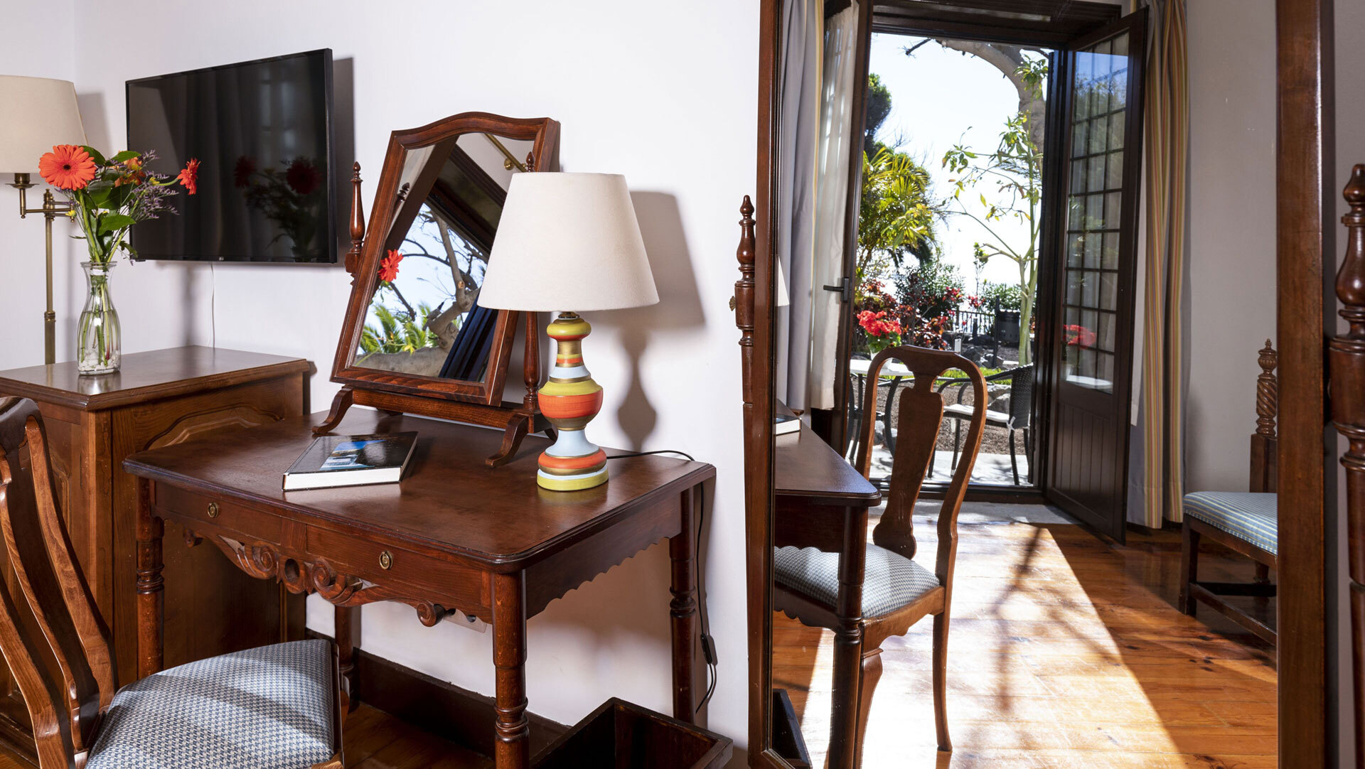Gemütlich eingerichtetes Zimmer im Parador Conde de la Gomera mit antiken Möbeln und Terrassenzugang zum Garten.