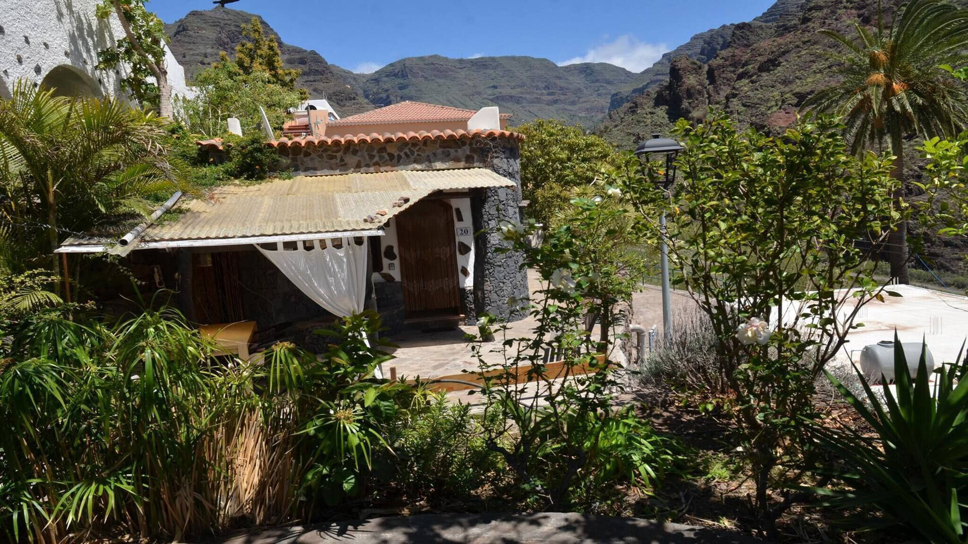 Die Casa Corma fügt sich mit Natursteinmauern und Terrakottadach in die schroffe Bergkulisse des Valle Gran Rey.