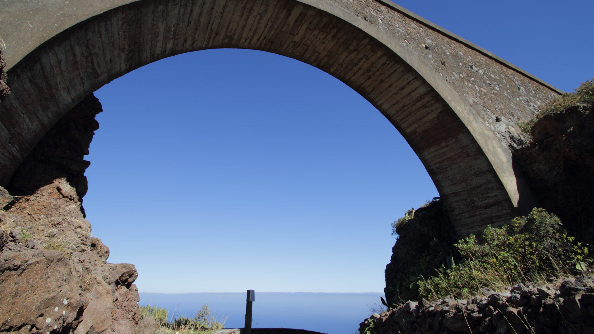 Blick durch den Bogen des Aquädukts über dem Zugangsweg zum Mirador Ermita del Santo