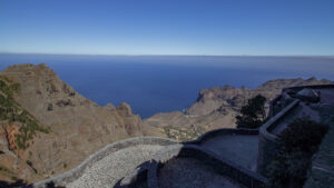 Blick über die geschwungene, gemauerte Aussichtsplattform des Mirador Ermita del Santo auf Berge, Küste und Atlantik.