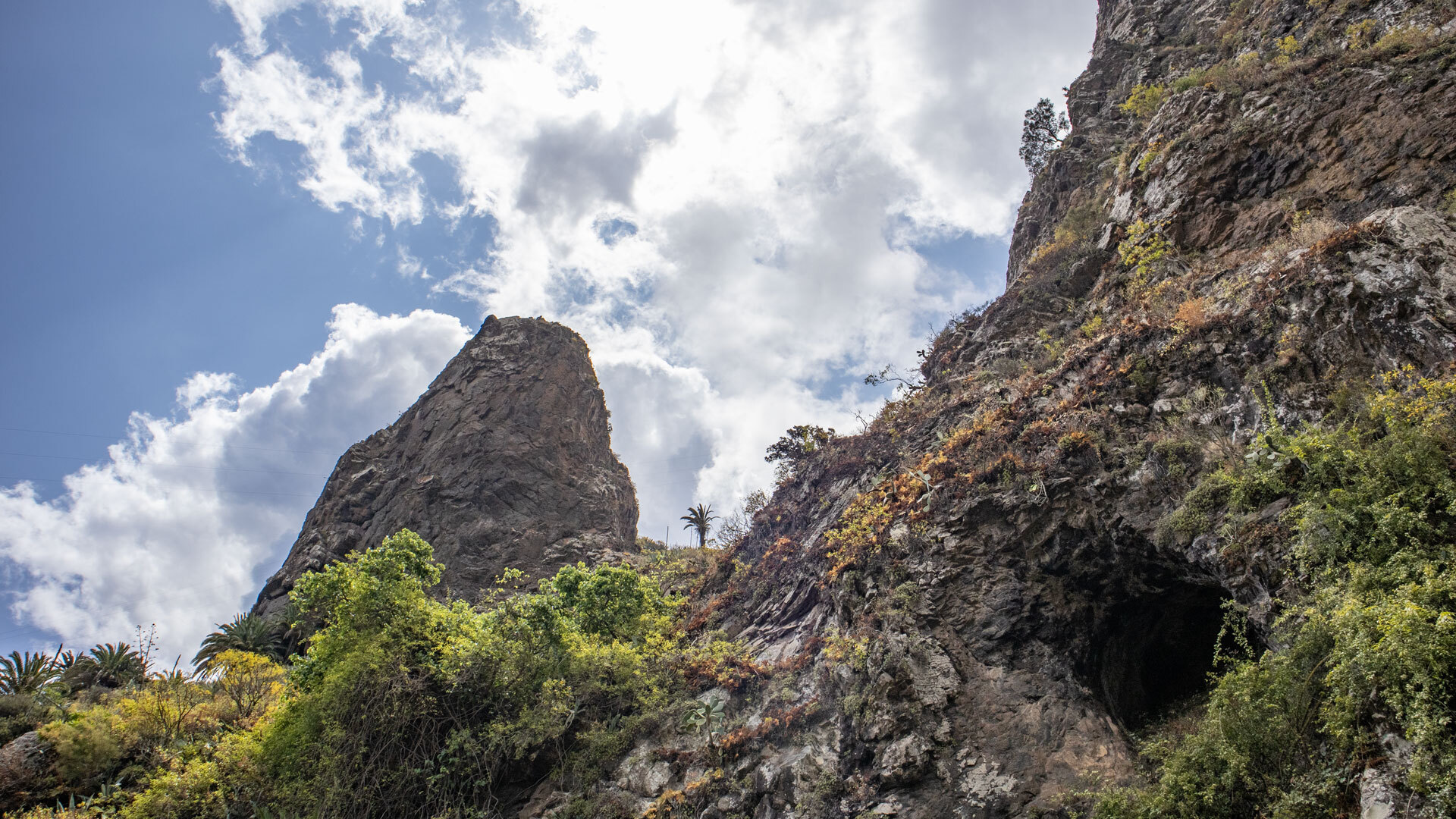 Felsturm des Roque Pedro mit angrenzender Höhle in der zerklüfteten Felswand bei Hermigua.