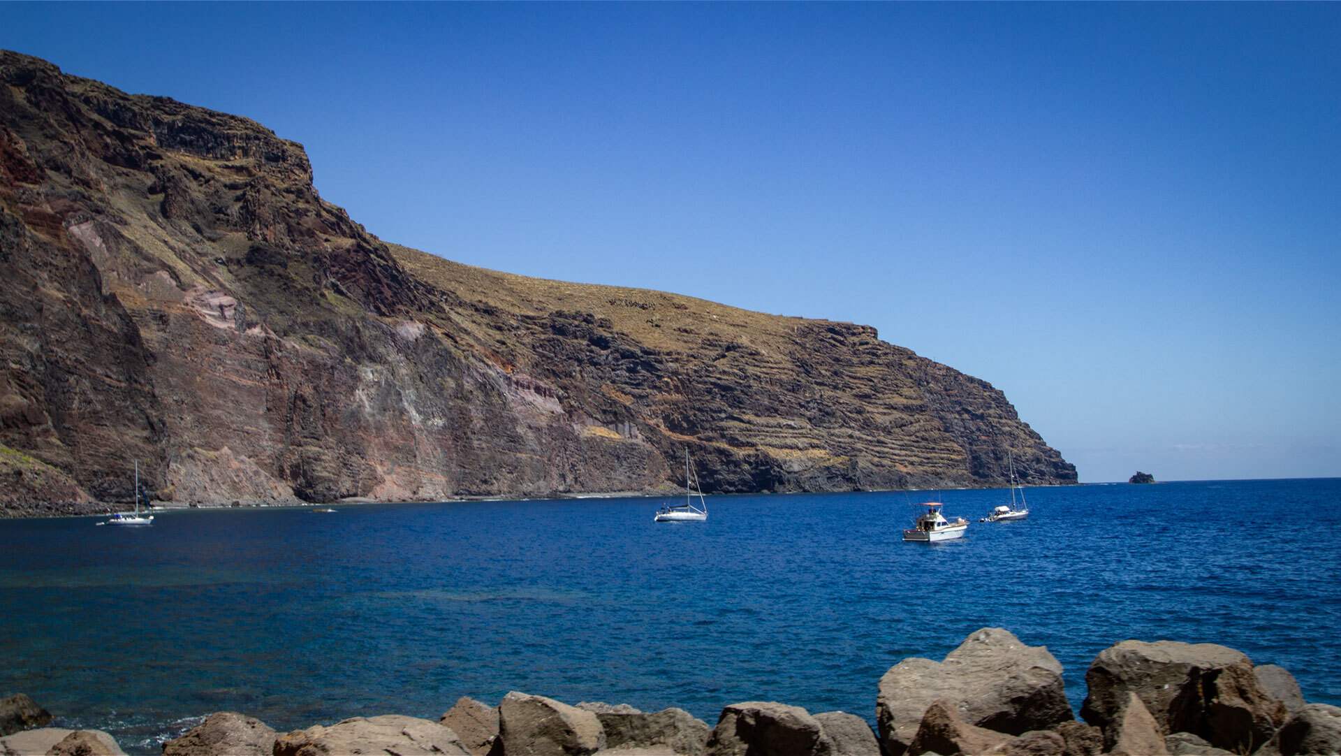 Die markante Steilküste rahmt den Hafen Vueltas auf La Gomera ein und prägt das Landschaftsbild der Südküste.