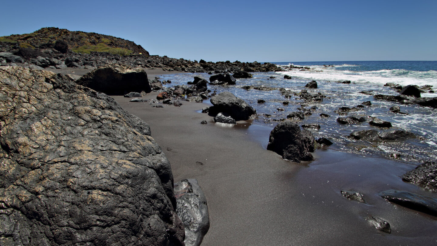 schwarzer Sandstrand zwischen Lavafelsen an der Playa del Inglés auf La Gomera