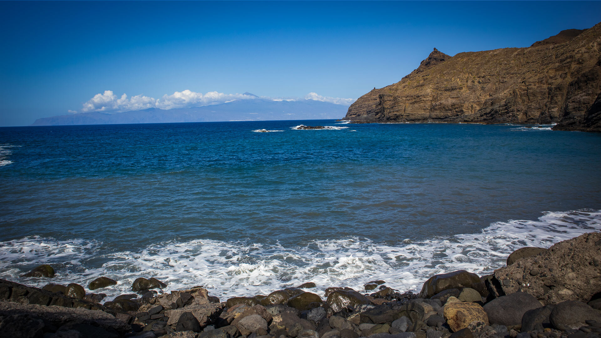 Blick über die Playa de la Caleta auf La Gomera zum Teide auf Teneriffa